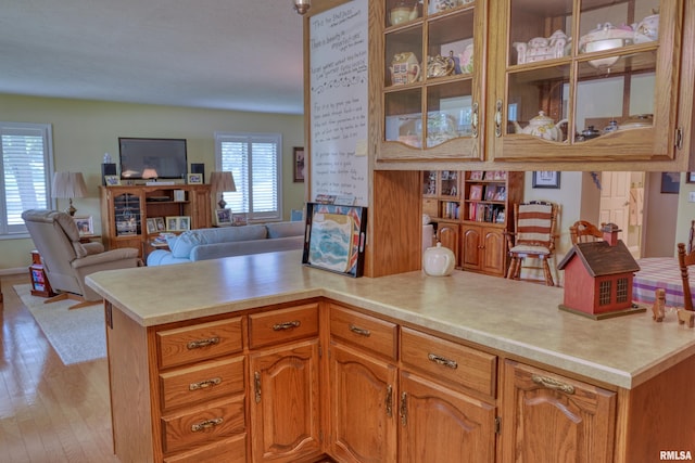 1382 Nicklaus Ln, Marion, IL 62959 - kitchen with light countertops, light wood-style floors, a peninsula, glass insert cabinets, and open floor plan