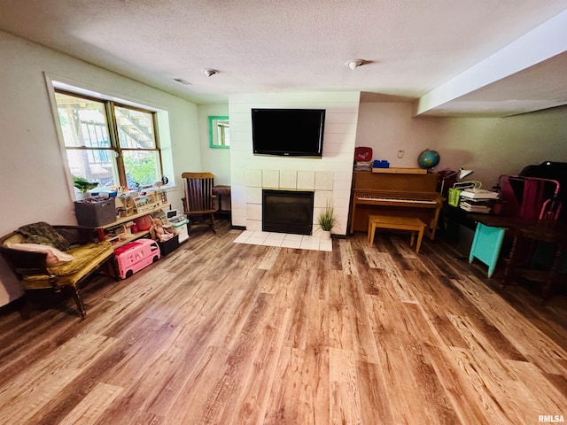 348 Medlin Rd, Walnut Hill, IL 62893 - living area with wood finished floors, a textured ceiling, and a tiled fireplace