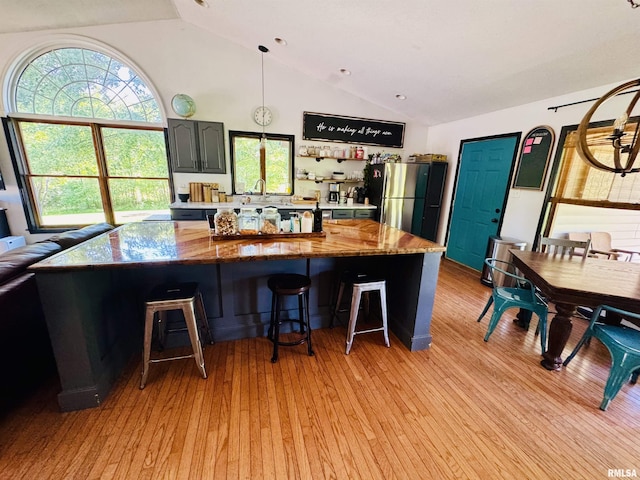348 Medlin Rd, Walnut Hill, IL 62893 - kitchen with a kitchen bar, freestanding refrigerator, light wood finished floors, light stone countertops, and high vaulted ceiling