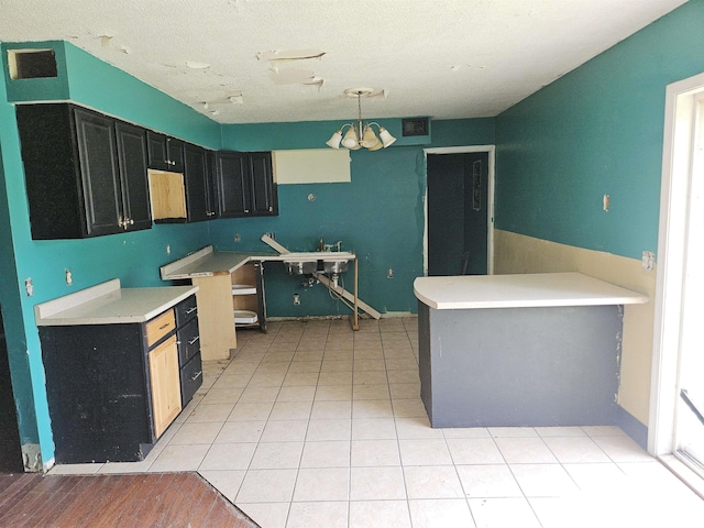 1605 E Pickett Ln, Marion, IL 62959 - kitchen with dark cabinetry, a chandelier, decorative light fixtures, and light countertops