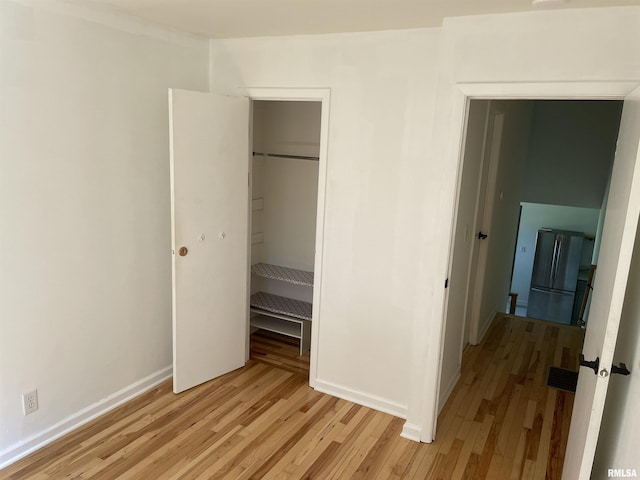 304 S Plover Dr, Carbondale, IL 62901 - unfurnished bedroom with freestanding refrigerator, light wood-style floors, and a closet