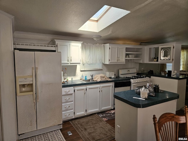120 E 1st St, Bonnie, IL 62816 - kitchen featuring white appliances, a skylight, open shelves, dark countertops, and white cabinets
