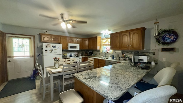 902 N Buchanan St, Benton, IL 62812 - kitchen featuring white appliances, a peninsula, a breakfast bar area, and backsplash