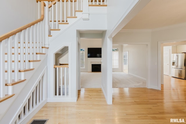 1506 Gleneagle Dr, Marion, IL 62959 - staircase featuring crown molding, wood finished floors, a fireplace, and a high ceiling
