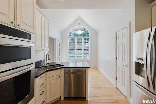 1506 Gleneagle Dr, Marion, IL 62959 - kitchen featuring appliances with stainless steel finishes, light wood-style flooring, cream cabinetry, vaulted ceiling, and a peninsula