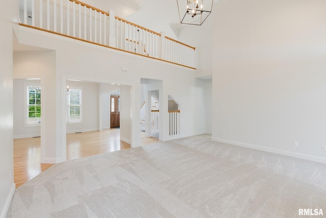 1506 Gleneagle Dr, Marion, IL 62959 - unfurnished living room with carpet flooring, a chandelier, stairway, and a towering ceiling