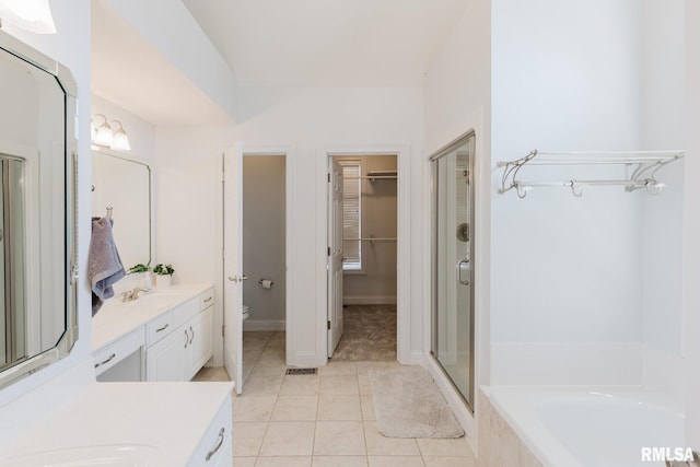 1506 Gleneagle Dr, Marion, IL 62959 - full bathroom with vanity, a spacious closet, tile patterned flooring, a bath, and a stall shower