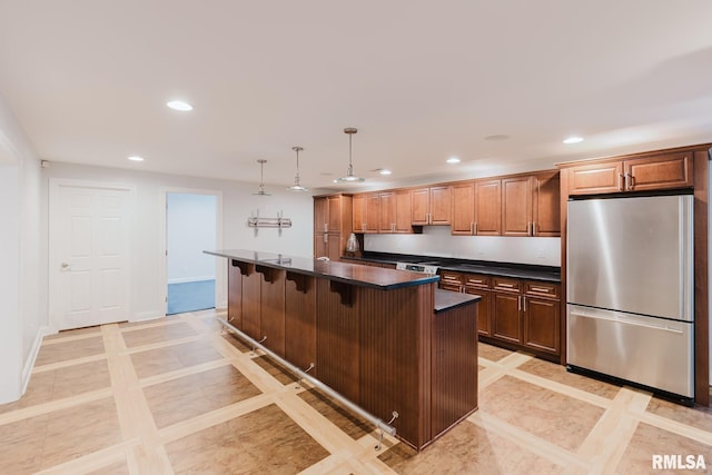 1506 Gleneagle Dr, Marion, IL 62959 - kitchen featuring freestanding refrigerator, dark countertops, recessed lighting, inlaid floor details, and a kitchen bar