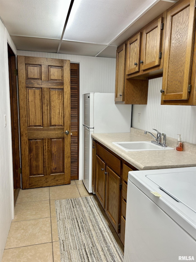 304 May Apple Ln, Carbondale, IL 62903 - kitchen featuring brown cabinets, light countertops, light tile patterned floors, and washer / clothes dryer