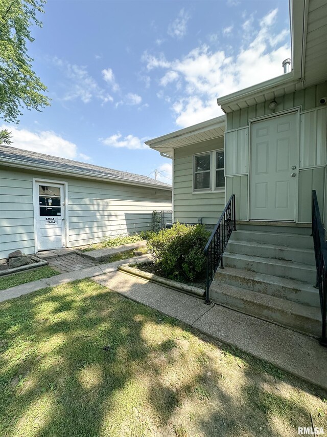 817 W Hendrickson St, Marion, IL 62959 - view of exterior entry with board and batten siding and a lawn
