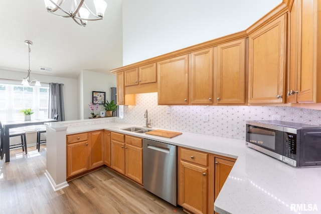 1600 S Eugene Ln, Marion, IL 62959 - kitchen with appliances with stainless steel finishes, light wood-type flooring, a peninsula, a chandelier, and decorative backsplash
