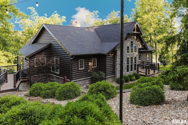 3525 Parrish Ridge Ln, Goreville, IL 62939 - view of property exterior with a deck, stone siding, a chimney, and roof with shingles