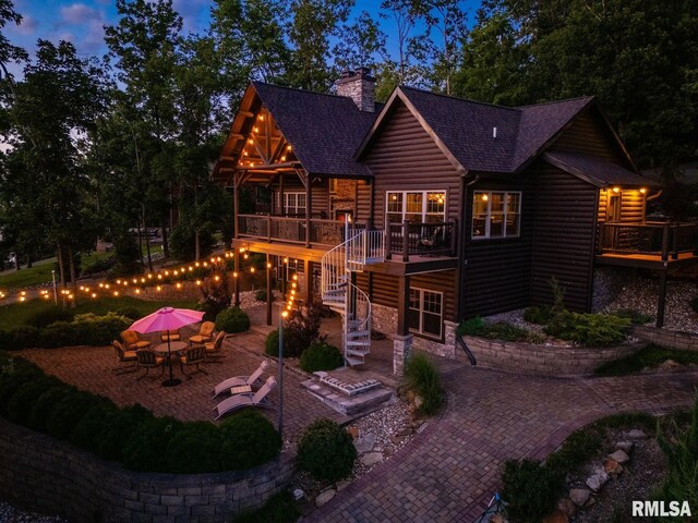 3525 Parrish Ridge Ln, Goreville, IL 62939 - rear view of house featuring stairway, faux log siding, a patio, a chimney, and roof with shingles