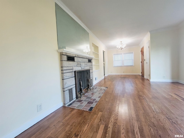 119 S 6th St SE, Clay City, IL 62824 - unfurnished living room featuring a chandelier, ornamental molding, a stone fireplace, dark wood finished floors, and built in features