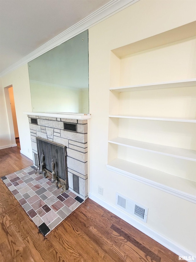 119 S 6th St SE, Clay City, IL 62824 - unfurnished living room featuring ornamental molding, a stone fireplace, wood finished floors, and built in shelves
