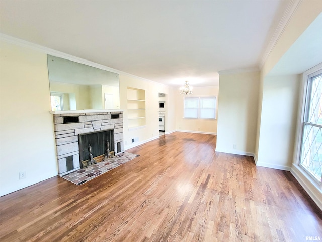 119 S 6th St SE, Clay City, IL 62824 - unfurnished living room featuring ornamental molding, wood finished floors, a fireplace, a chandelier, and built in features