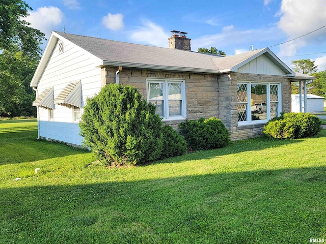 119 S 6th St SE, Clay City, IL 62824 - view of property exterior with stone siding, a lawn, and a chimney