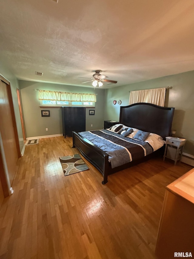 303 S College Blvd, Carmi, IL 62821 - bedroom featuring light wood-style floors, a ceiling fan, and a baseboard radiator