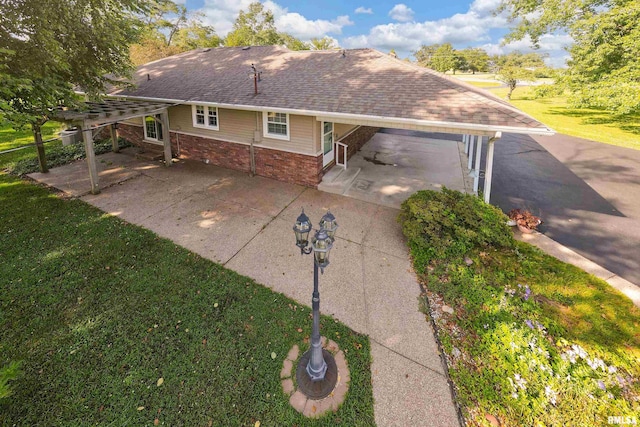 4341 Market Rd, Marion, IL 62959 - back of house featuring a carport, roof with shingles, brick siding, driveway, and a lawn