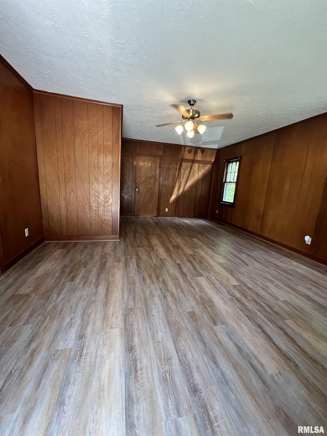 1409 N Van Buren, Marion, IL 62959 - unfurnished bedroom with wood finished floors, wood walls, a textured ceiling, and ceiling fan