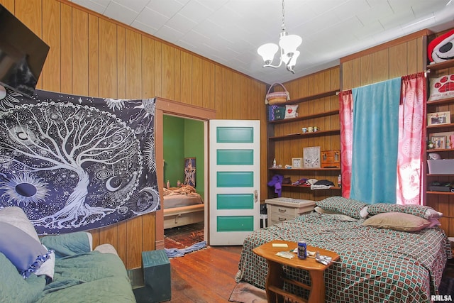 827 W Raymond St, Harrisburg, IL 62946 - bedroom with wood-type flooring, a chandelier, and wood walls