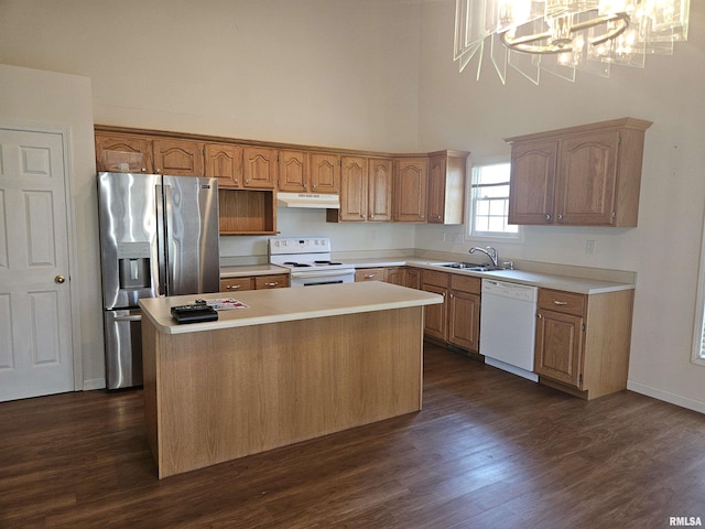 1905 N Dawn Dr, Marion, IL 62959 - kitchen featuring white appliances, under cabinet range hood, a towering ceiling, a center island, and a chandelier