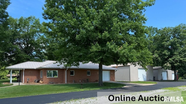 1308 Shawnee Trl, Carterville, IL 62918 - view of front facade with a front yard, brick siding, a standing seam roof, a garage, and a metal roof