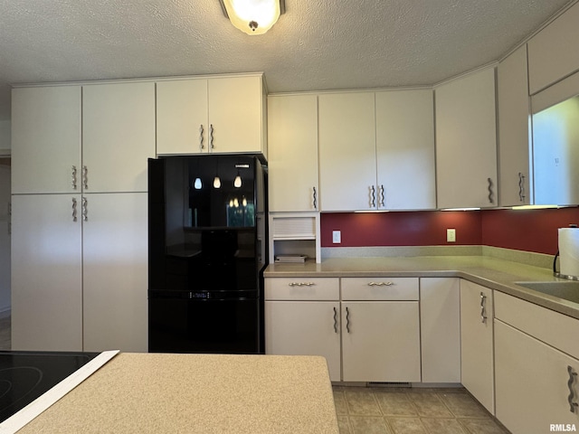1308 Shawnee Trl, Carterville, IL 62918 - kitchen with black appliances, a textured ceiling, light countertops, and white cabinetry