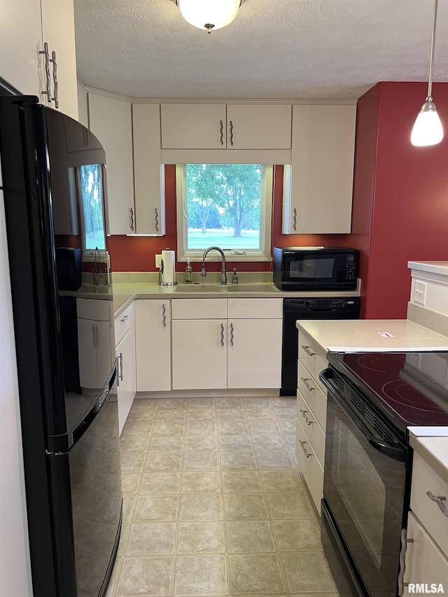 1308 Shawnee Trl, Carterville, IL 62918 - kitchen with black appliances, light countertops, a textured ceiling, white cabinetry, and decorative light fixtures