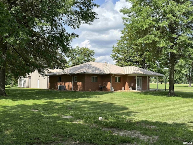 1308 Shawnee Trl, Carterville, IL 62918 - back of house featuring a lawn, a metal roof, and brick siding