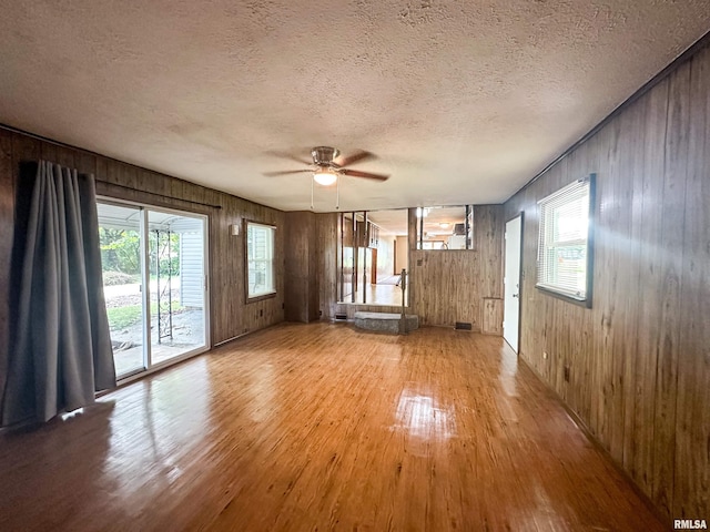 215 S Sunny Slope St, West Frankfort, IL 62896 - unfurnished living room with light wood finished floors, ceiling fan, a textured ceiling, and wooden walls