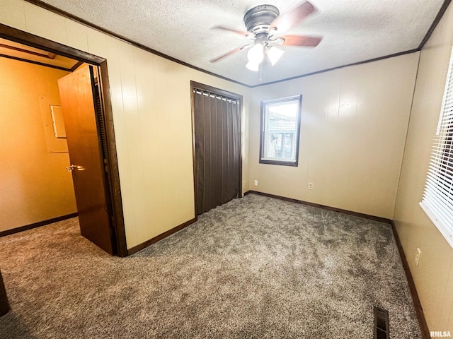 215 S Sunny Slope St, West Frankfort, IL 62896 - unfurnished bedroom featuring ornamental molding, carpet floors, a closet, a textured ceiling, and a ceiling fan