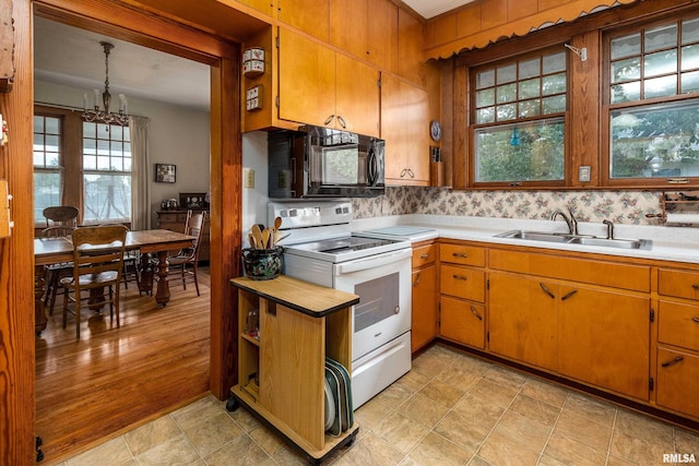 2011 Logan St, Murphysboro, IL 62966 - kitchen with white electric range, black microwave, light countertops, and a chandelier
