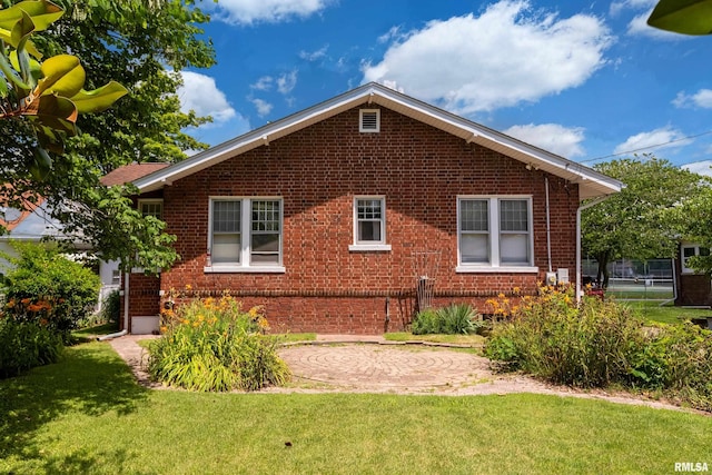 2011 Logan St, Murphysboro, IL 62966 - view of side of property with brick siding, a lawn, and a patio
