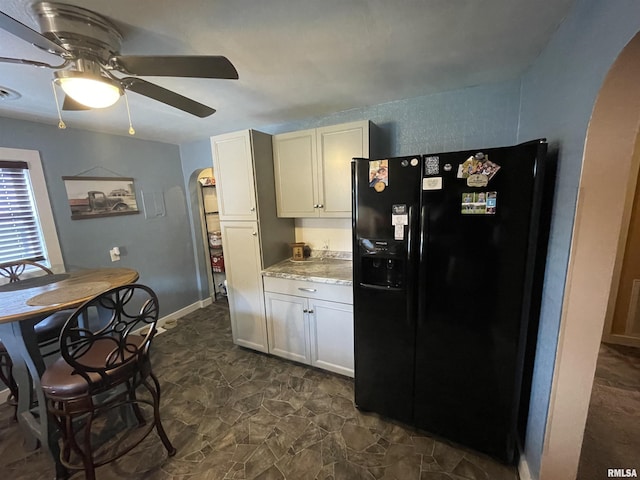 204 Oak St, Odin, IL 62870 - kitchen with black refrigerator with ice dispenser, arched walkways, ceiling fan, and dark stone finish flooring
