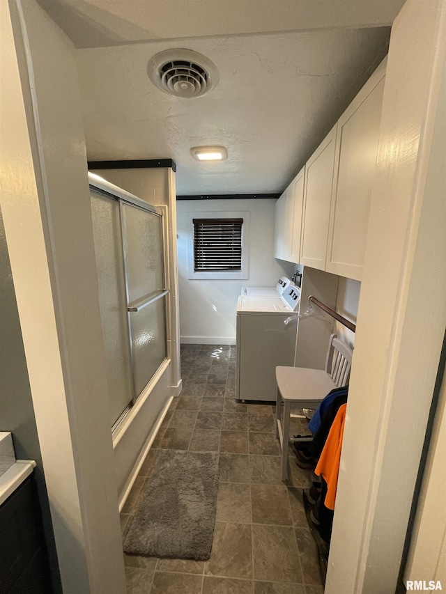 204 Oak St, Odin, IL 62870 - washroom with separate washer and dryer, cabinet space, and dark stone finish flooring