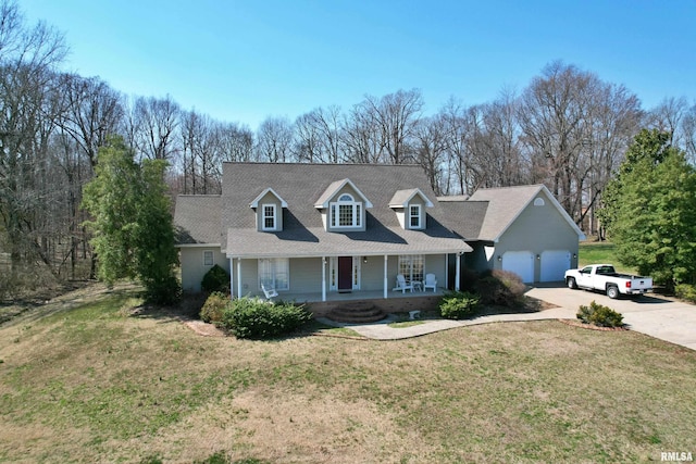 43 E Lakewood Dr, Metropolis, IL 62960 - new england style home with a porch, concrete driveway, a front lawn, a shingled roof, and view of wooded area