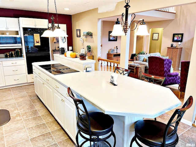 43 E Lakewood Dr, Metropolis, IL 62960 - kitchen with black appliances, light countertops, a kitchen island, and a kitchen breakfast bar