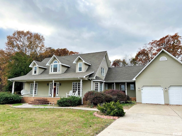 43 E Lakewood Dr, Metropolis, IL 62960 - new england style home featuring a porch, concrete driveway, roof with shingles, a front lawn, and a garage