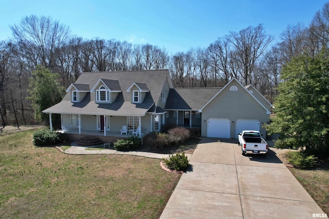 43 E Lakewood Dr, Metropolis, IL 62960 - cape cod-style house with a porch, driveway, a front lawn, an attached garage, and view of wooded area