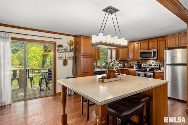 468 Clifty Heights Dr, Marion, IL 62959 - kitchen with appliances with stainless steel finishes, brown cabinets, decorative backsplash, a kitchen bar, and light countertops