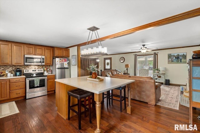 468 Clifty Heights Dr, Marion, IL 62959 - kitchen featuring appliances with stainless steel finishes, open floor plan, light countertops, brown cabinetry, and crown molding