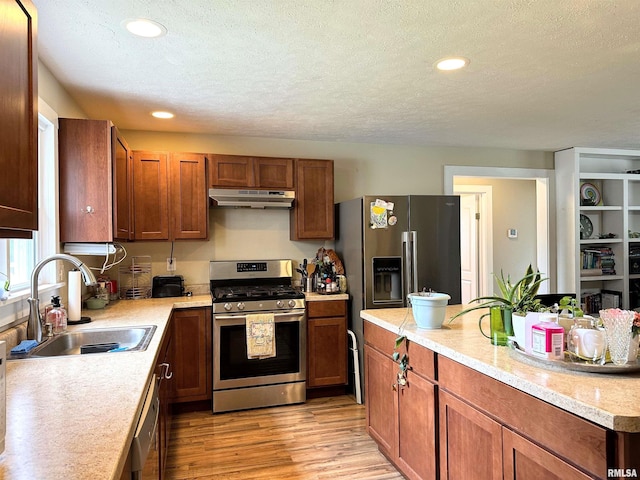 501 Cedar Creek Rd, Makanda, IL 62958 - kitchen with stainless steel appliances, under cabinet range hood, light countertops, light wood-style flooring, and a textured ceiling