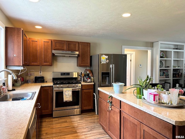 501 Cedar Creek Rd, Makanda, IL 62958 - kitchen with stainless steel appliances, under cabinet range hood, light wood-type flooring, light countertops, and a textured ceiling