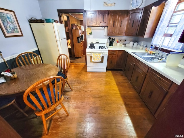 113 SW Mead St, Clay City, IL 62824 - kitchen with white appliances, light wood finished floors, light countertops, and dark brown cabinets