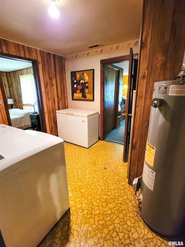 113 SW Mead St, Clay City, IL 62824 - laundry room featuring gas water heater, wood walls, and light stone finish floors