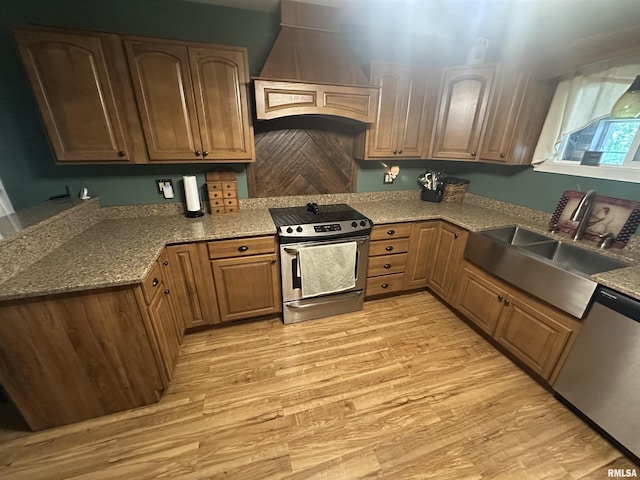 11382 Petroff Rd, Benton, IL 62812 - kitchen featuring stainless steel appliances, custom range hood, light wood-type flooring, light stone counters, and brown cabinets