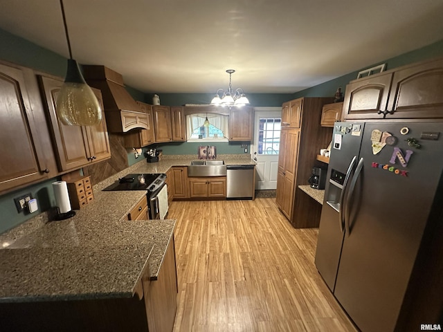 11382 Petroff Rd, Benton, IL 62812 - kitchen with appliances with stainless steel finishes, premium range hood, a chandelier, light wood-type flooring, and dark stone countertops