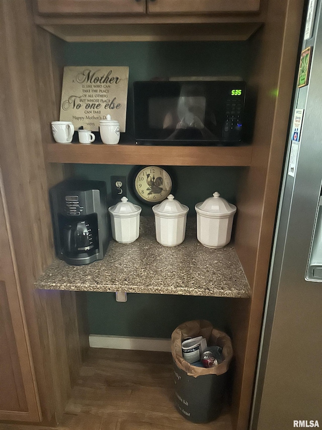 11382 Petroff Rd, Benton, IL 62812 - detailed view of freestanding refrigerator, wood finished floors, and black microwave