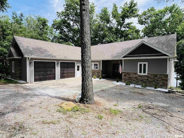65 Stony Pt, Goreville, IL 62939 - ranch-style house featuring stone siding, an attached garage, a shingled roof, and concrete driveway
